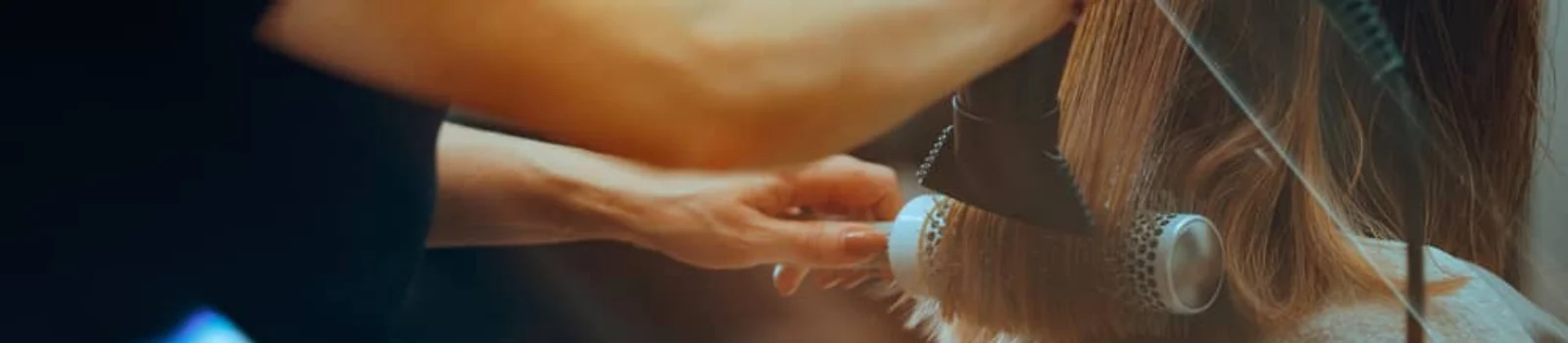 A hairstylist blow-drying and styling hair for a blowout