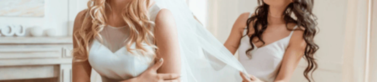 Bridesmaid helps adjust veil while ensuring bride’s bridesmaid blowout hair remains flawless and styled
