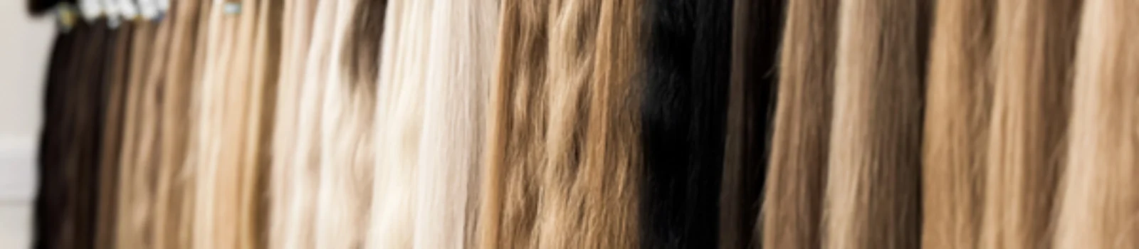 Various shades of hair extensions displayed in a salon showing different textures and lengths for styling