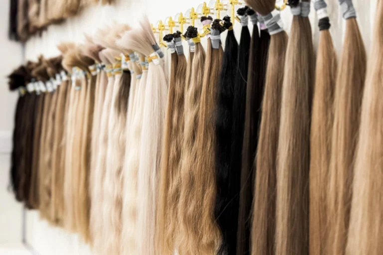 Various shades of hair extensions displayed in a salon showing different textures and lengths for styling