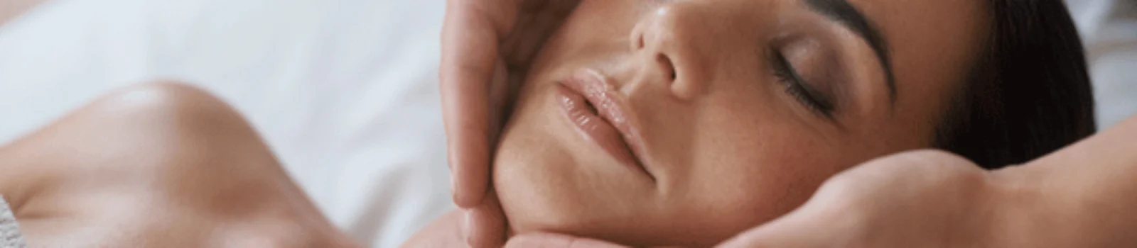 A woman receives a relaxing face massage at a spa, focusing on skin relaxation and rejuvenation