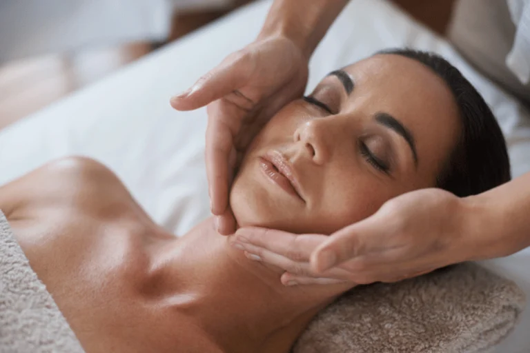 A woman receives a relaxing face massage at a spa, focusing on skin relaxation and rejuvenation