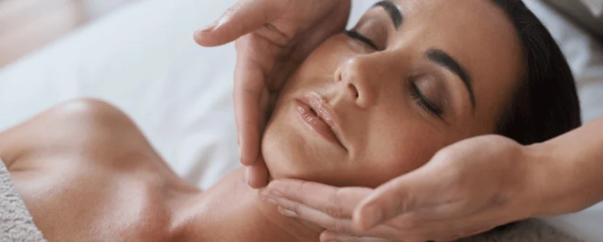 A woman receives a relaxing face massage at a spa, focusing on skin relaxation and rejuvenation