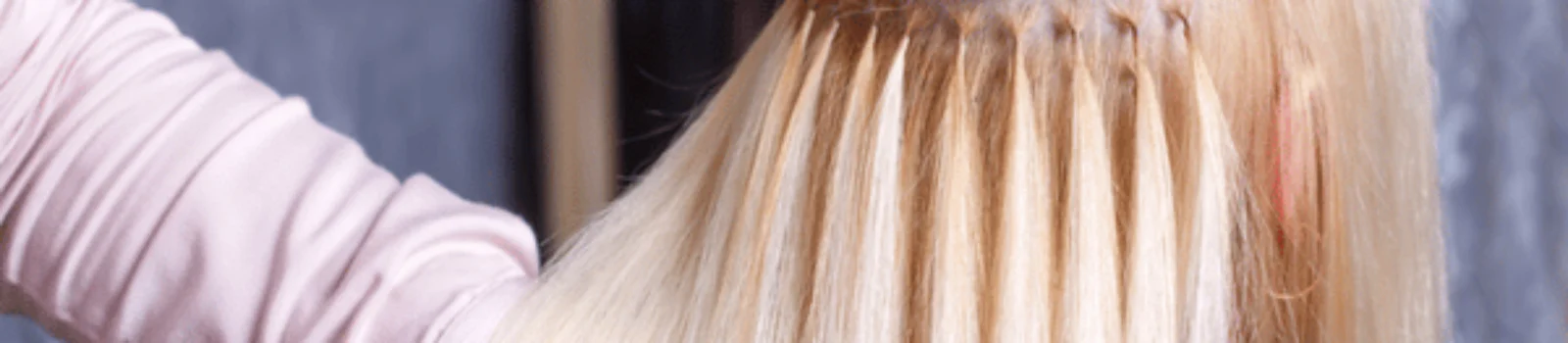 Stylist applies bonded strands during installation; explaining average cost of extensions and maintenance for clients