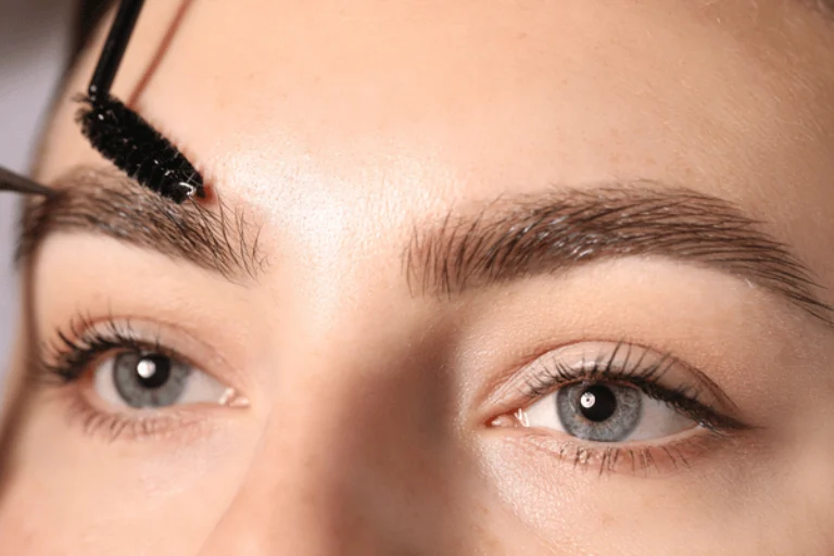 Close-up of brow brushing during appointment, showcasing lash and brow services for polished look today